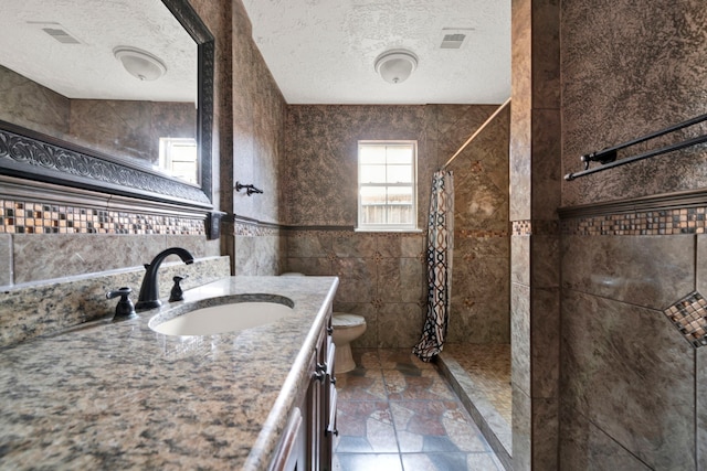 bathroom featuring vanity, a shower with shower curtain, a textured ceiling, and toilet