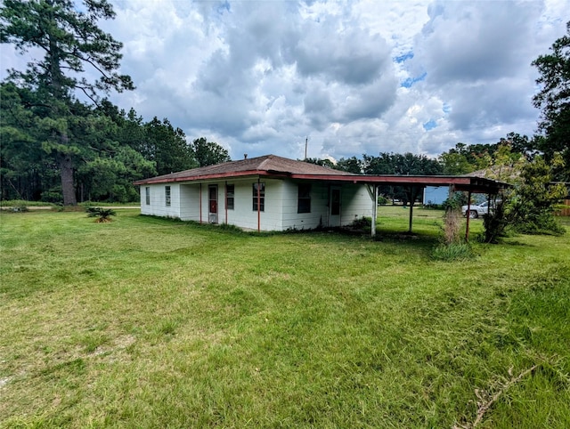 view of side of property featuring a carport and a lawn