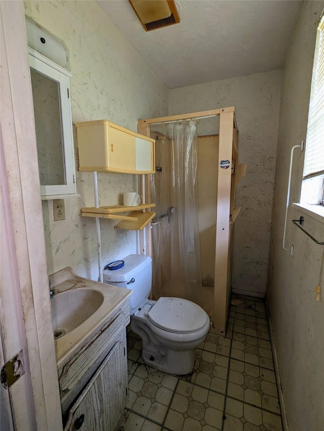 bathroom with vanity, toilet, and curtained shower