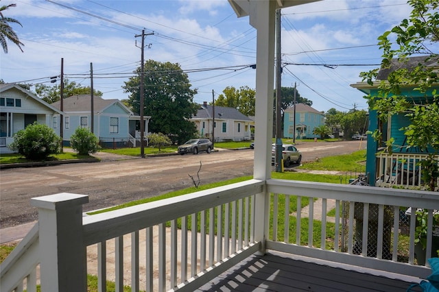 wooden deck featuring covered porch and a residential view