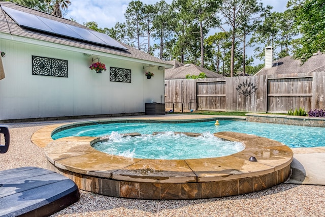 view of pool with an in ground hot tub, pool water feature, and central AC