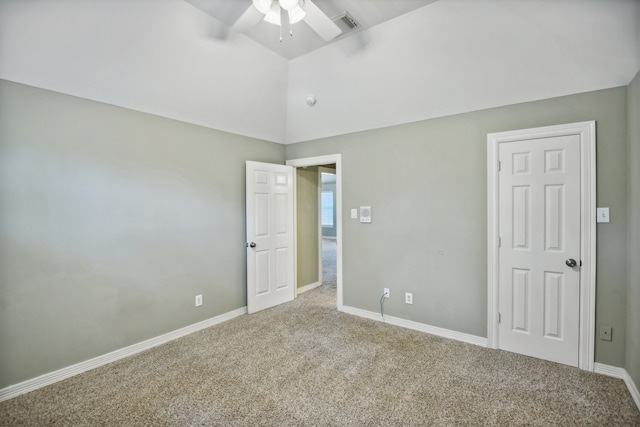 carpeted spare room with ceiling fan and vaulted ceiling