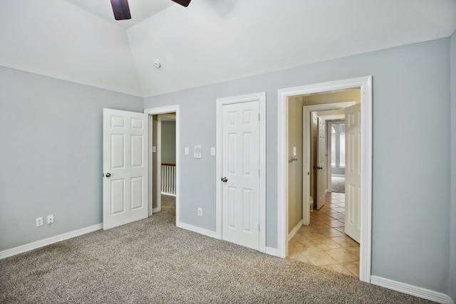 unfurnished bedroom featuring ceiling fan, vaulted ceiling, and light colored carpet