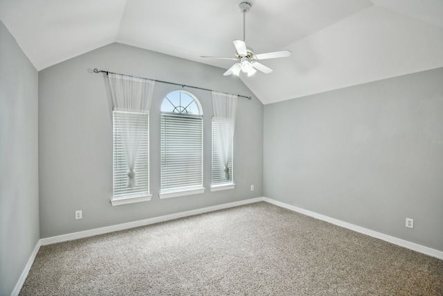 carpeted spare room with ceiling fan and vaulted ceiling