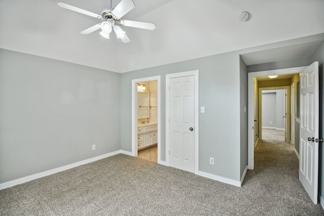 unfurnished bedroom with ensuite bathroom, carpet flooring, and ceiling fan