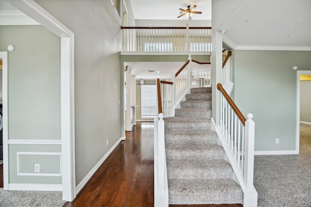 staircase featuring ceiling fan, dark hardwood / wood-style floors, and ornamental molding