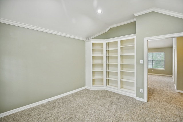 carpeted spare room with crown molding and vaulted ceiling