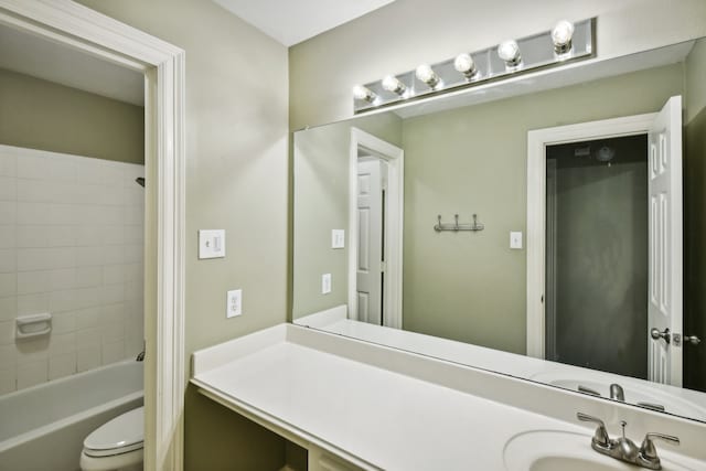 full bathroom with vanity, tiled shower / bath, and toilet