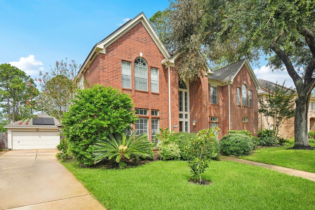 view of front property featuring a garage, solar panels, and a front yard