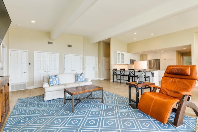 living room featuring hardwood / wood-style floors, beam ceiling, and a high ceiling