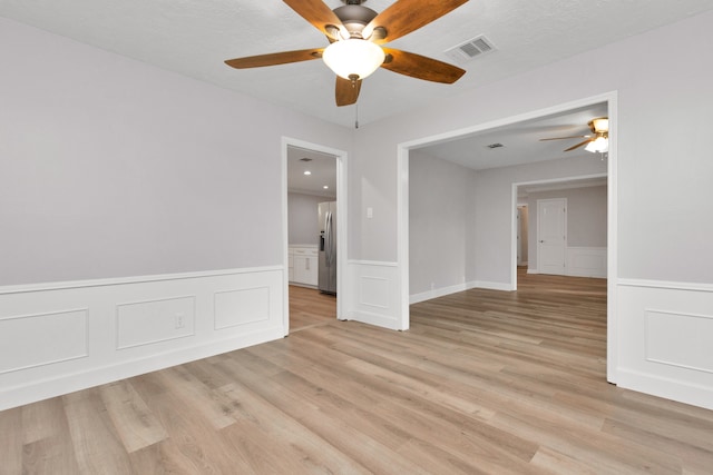 empty room with light hardwood / wood-style floors and ceiling fan