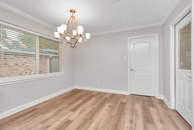 spare room with light hardwood / wood-style floors, a notable chandelier, and crown molding