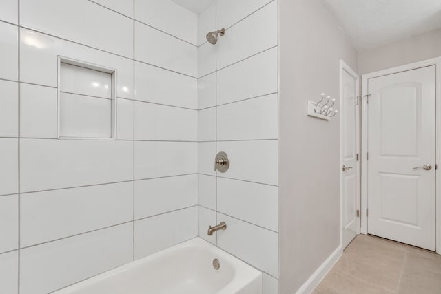 bathroom with tiled shower / bath and tile patterned flooring