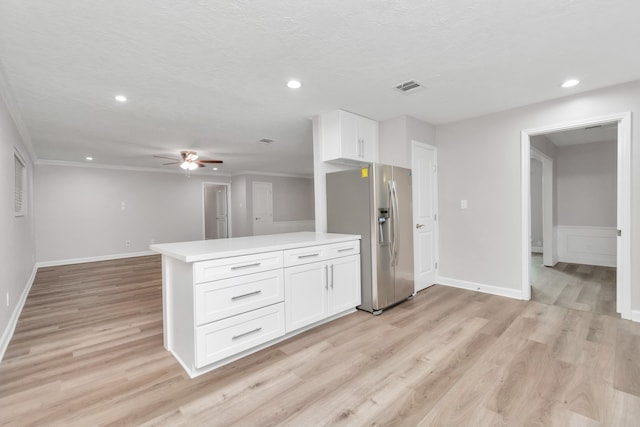 kitchen featuring ceiling fan, white cabinets, stainless steel fridge, light hardwood / wood-style flooring, and a textured ceiling