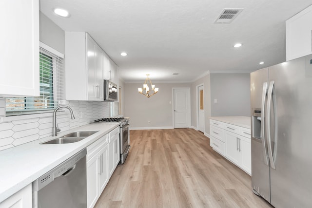 kitchen with light hardwood / wood-style floors, appliances with stainless steel finishes, white cabinetry, and sink