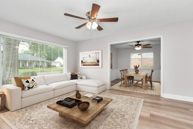 living room featuring light hardwood / wood-style floors and ceiling fan