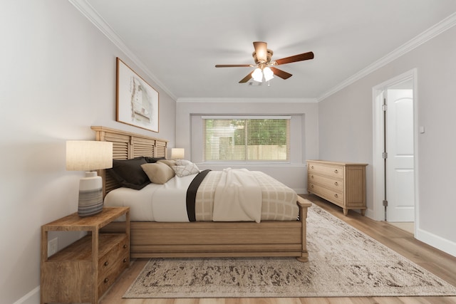 bedroom featuring ceiling fan, light wood-type flooring, and crown molding