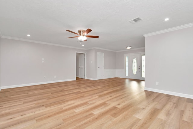 spare room featuring light hardwood / wood-style floors, a textured ceiling, crown molding, and ceiling fan