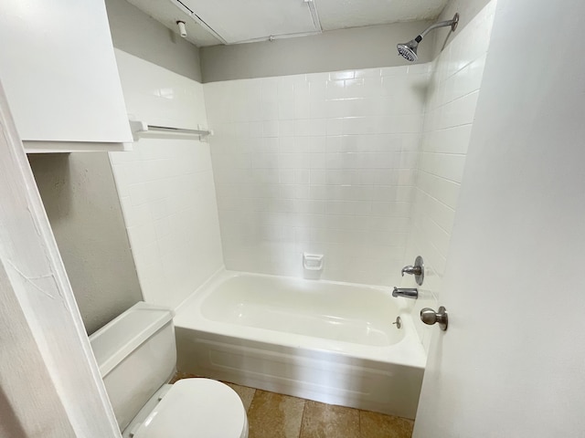 bathroom with tiled shower / bath combo, toilet, and tile patterned floors