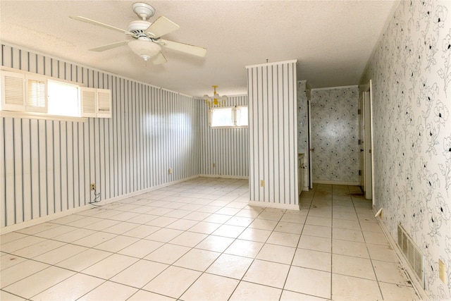 empty room with a textured ceiling, light tile patterned floors, and ceiling fan