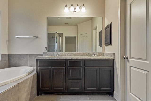 bathroom featuring tile patterned floors, independent shower and bath, and double sink vanity