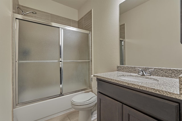 full bathroom featuring vanity, tile patterned flooring, enclosed tub / shower combo, and toilet