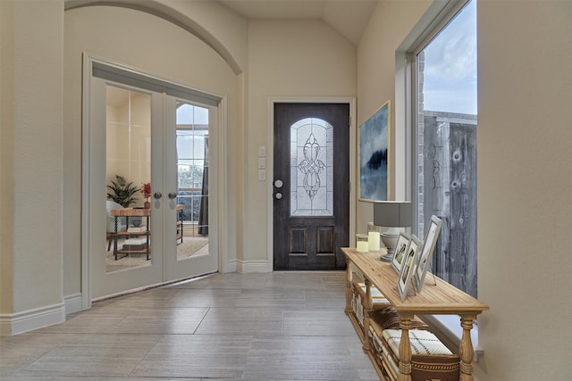 entrance foyer featuring light tile patterned flooring, lofted ceiling, and french doors