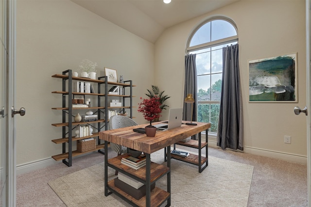 carpeted home office with vaulted ceiling