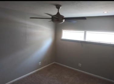 carpeted empty room featuring ceiling fan