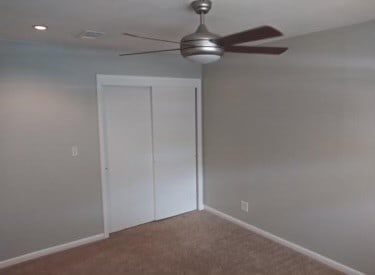 unfurnished bedroom featuring carpet, a closet, and ceiling fan