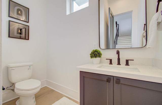 bathroom featuring wood-type flooring, vanity, and toilet