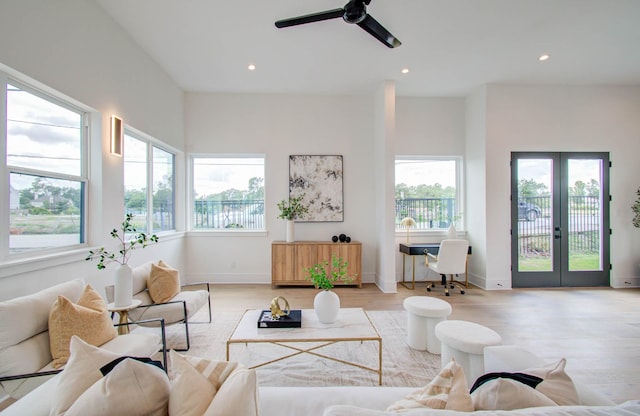 living room featuring ceiling fan, french doors, and light hardwood / wood-style floors