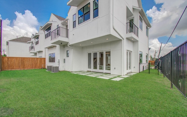 rear view of property featuring a lawn and french doors