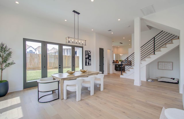 dining room with a wealth of natural light, french doors, and light wood-type flooring