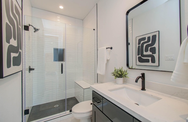 bathroom featuring vanity, toilet, and a shower with door