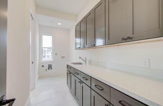 kitchen with light stone counters and sink