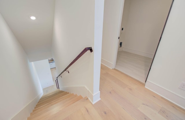 staircase with hardwood / wood-style floors