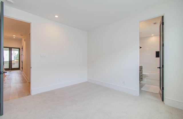 empty room featuring light colored carpet and french doors