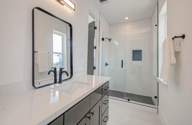 bathroom with vanity and a shower with door