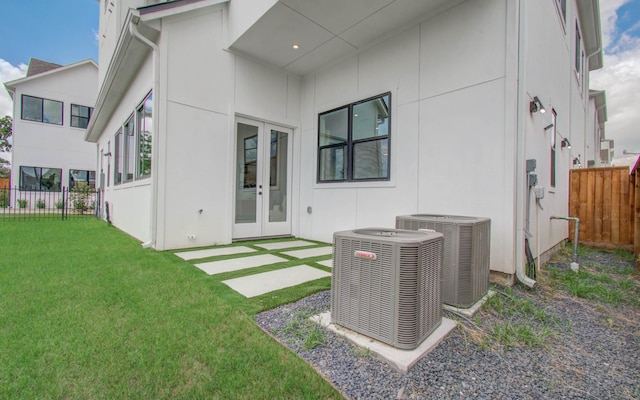 back of property with french doors, a yard, and central AC unit