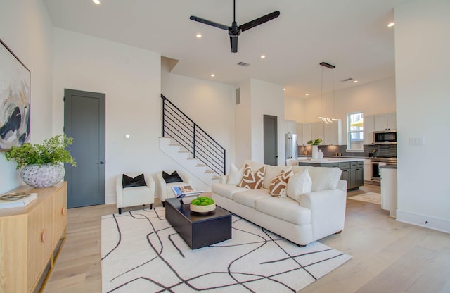 living room with ceiling fan and light wood-type flooring