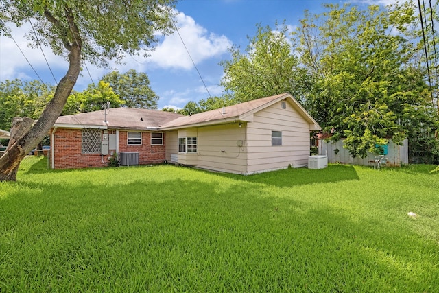 back of property featuring central AC and a yard