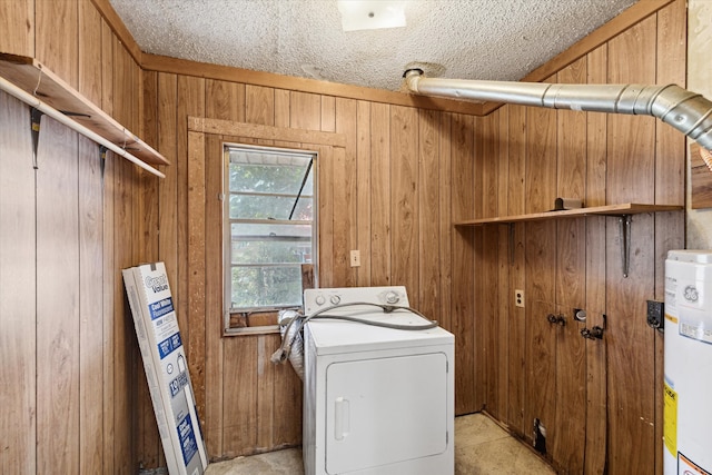 washroom with washer / dryer, a textured ceiling, wooden walls, and water heater