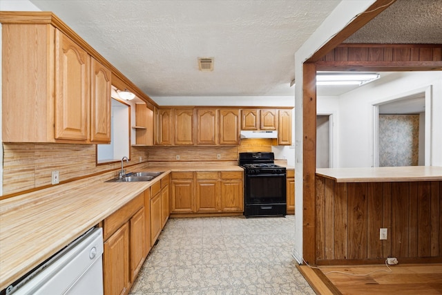 kitchen featuring white dishwasher, sink, light tile patterned floors, a textured ceiling, and black range with gas cooktop