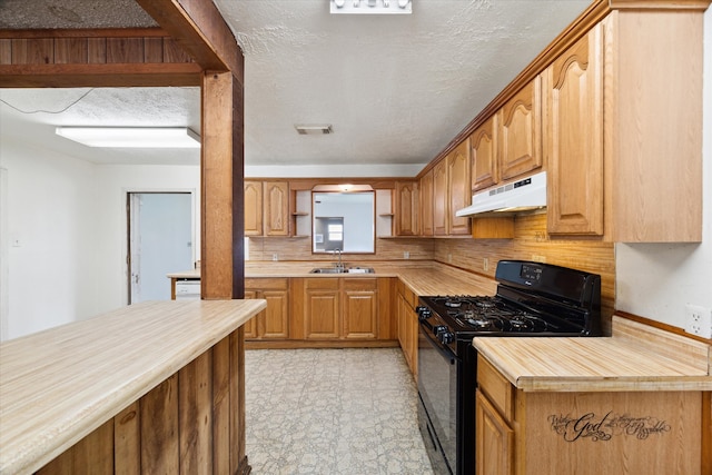 kitchen featuring sink, a textured ceiling, light tile patterned floors, and black gas range