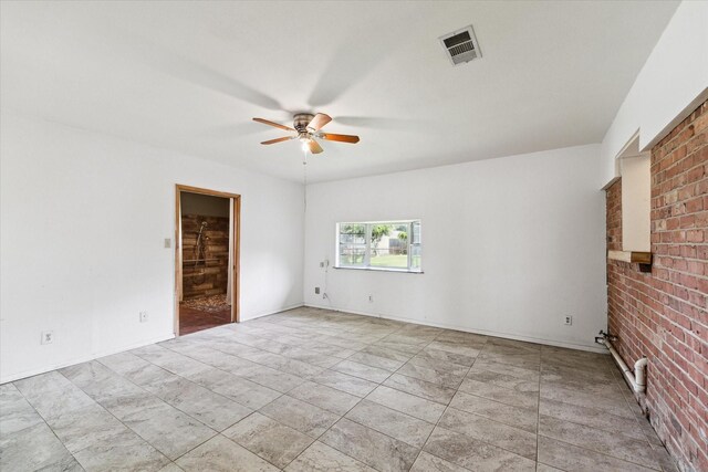 tiled spare room with brick wall and ceiling fan