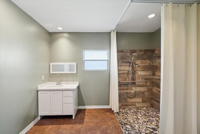 bathroom featuring tile patterned flooring, a shower, and vanity