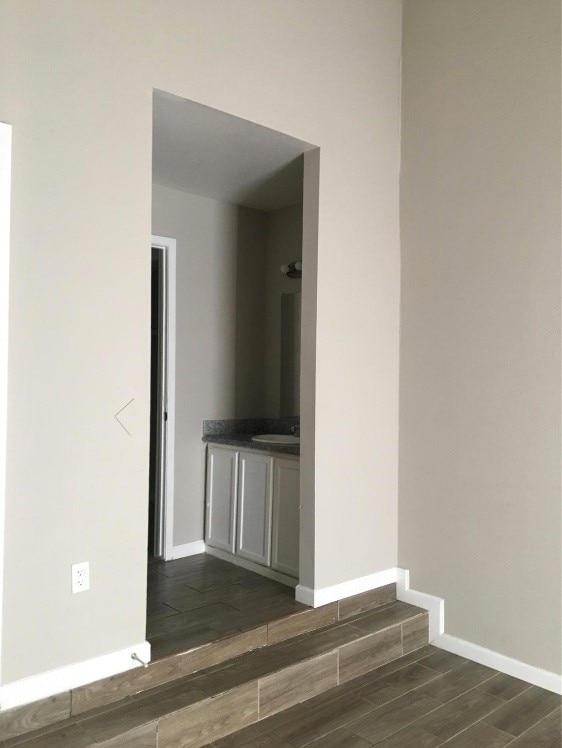 unfurnished room with dark hardwood / wood-style flooring and sink