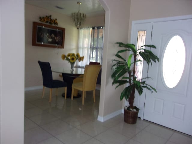 tiled foyer with a notable chandelier