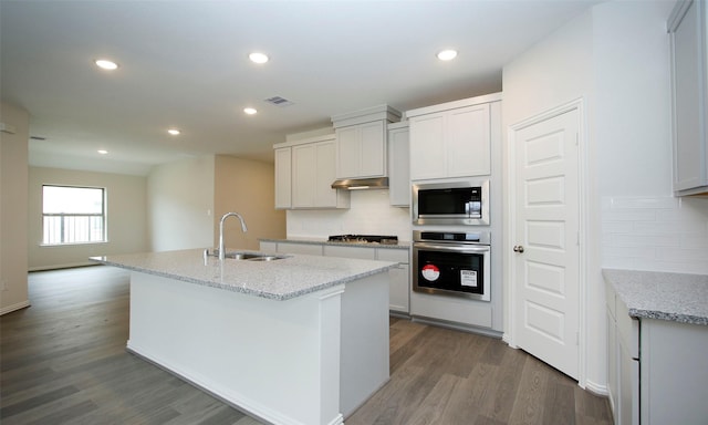 kitchen featuring white cabinetry, stainless steel appliances, a kitchen island with sink, and sink